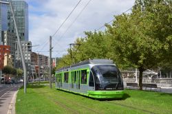 Straßenbahn Bilbao Tram CAF Urbos 1 in alter Farbgebung auf Rasengleis nahe der Station Pio Baroja