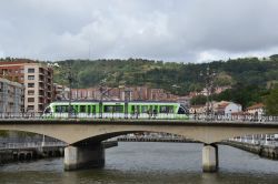 Straßenbahn Bilbao Tram CAF Urbos 1 auf der Brücke über den Fluss Nervion in der Innenstadt von Bilbao